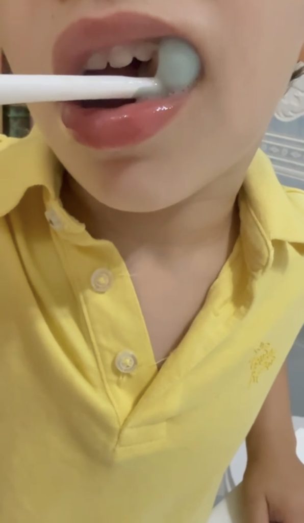 Dos niños se cepillan los dientes juntos en un baño cálido y soleado, promoviendo el cuidado dental.